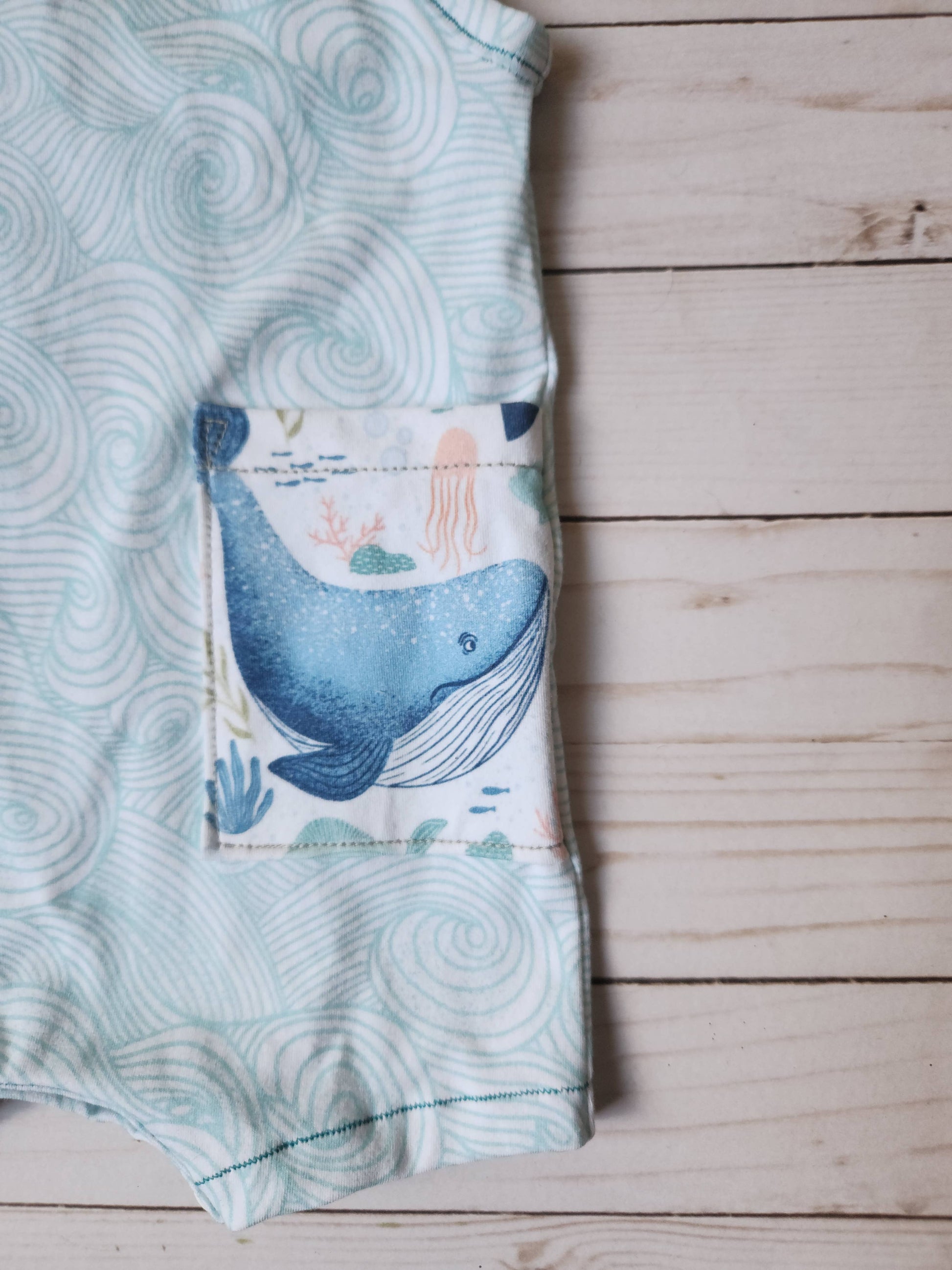 Wave tank romper for babies in teal wave print with whale pocket alternate view