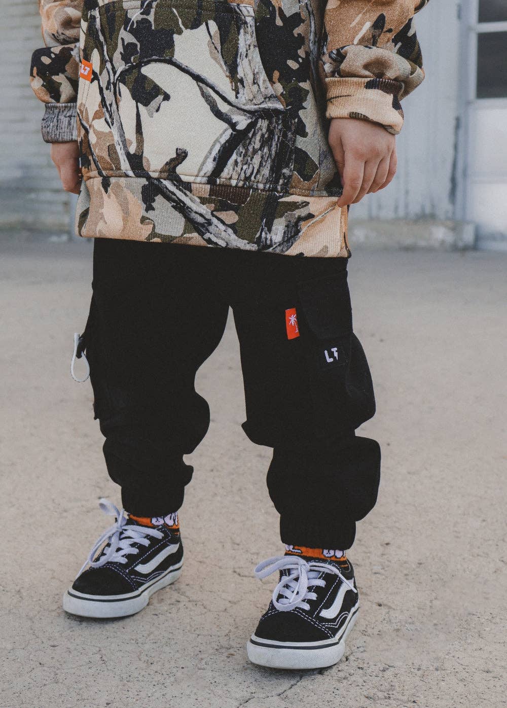 Black cargo pants for kids with functional pockets and elastic drawstring waist front view