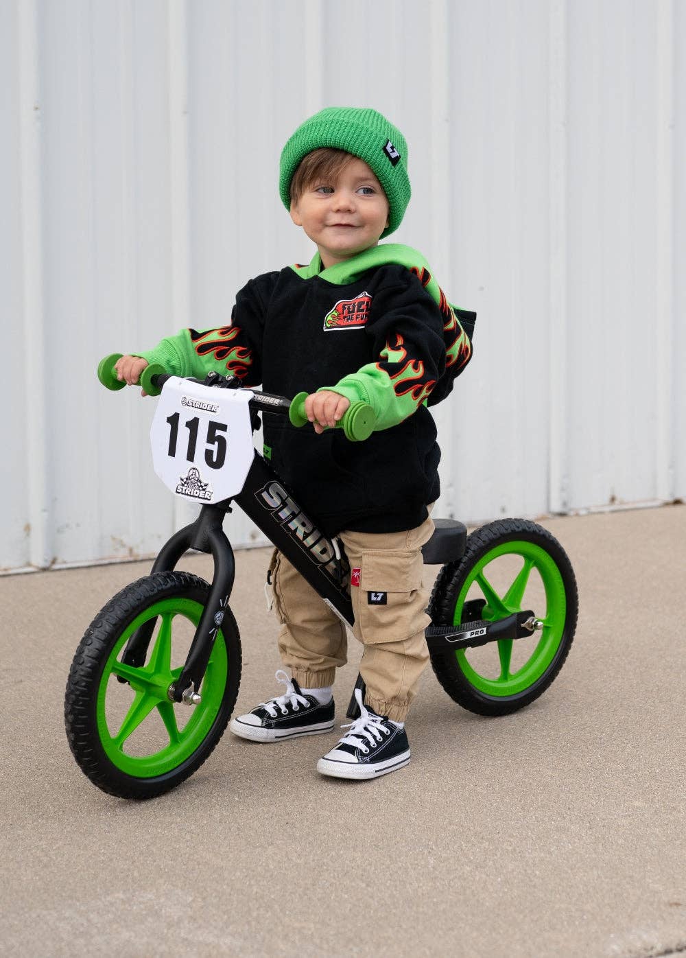 Kids black hoodie with green flames and red embroidery worn lifestyle shot