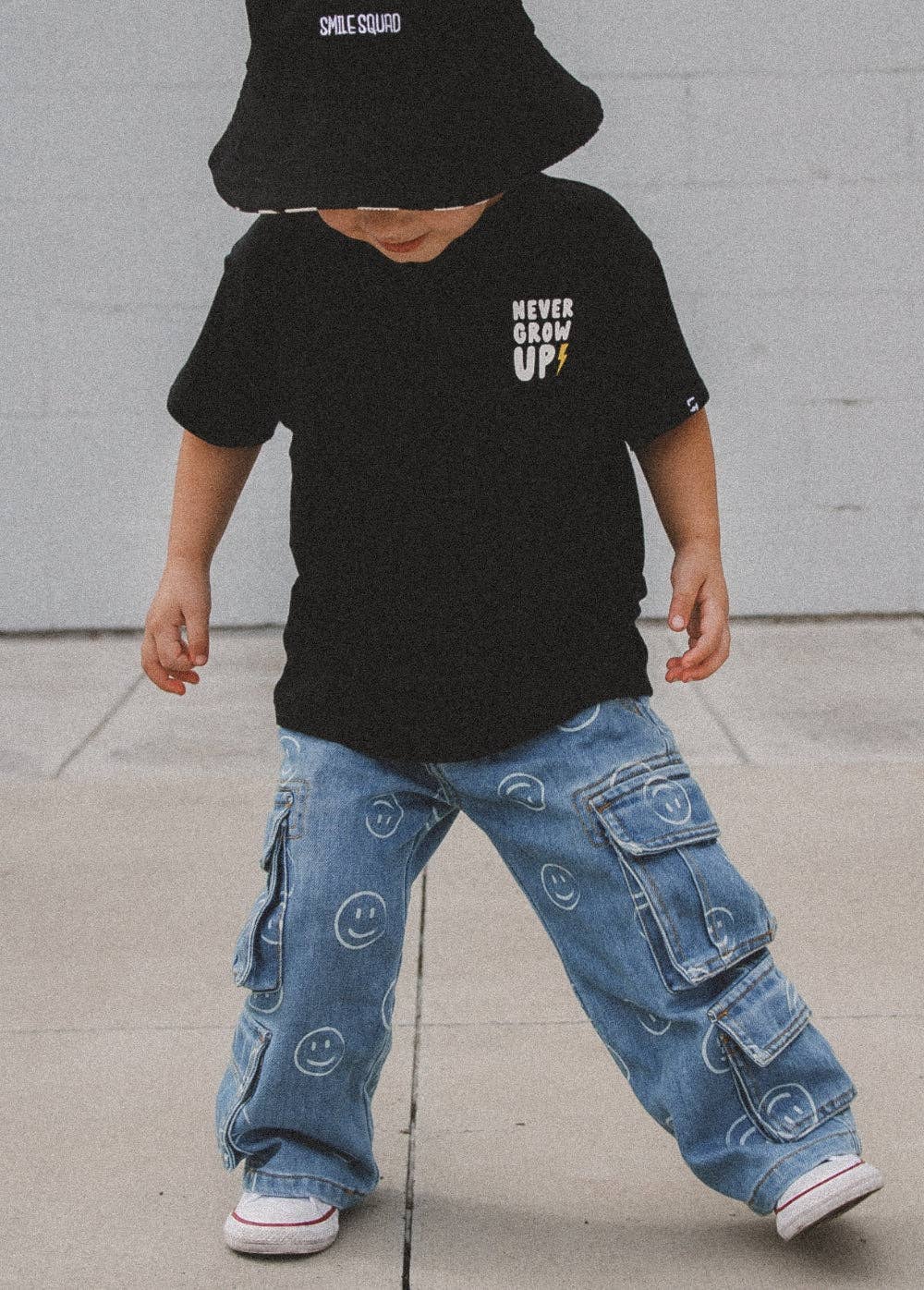 Smiley face print kids boutique jeans worn full length outfit view