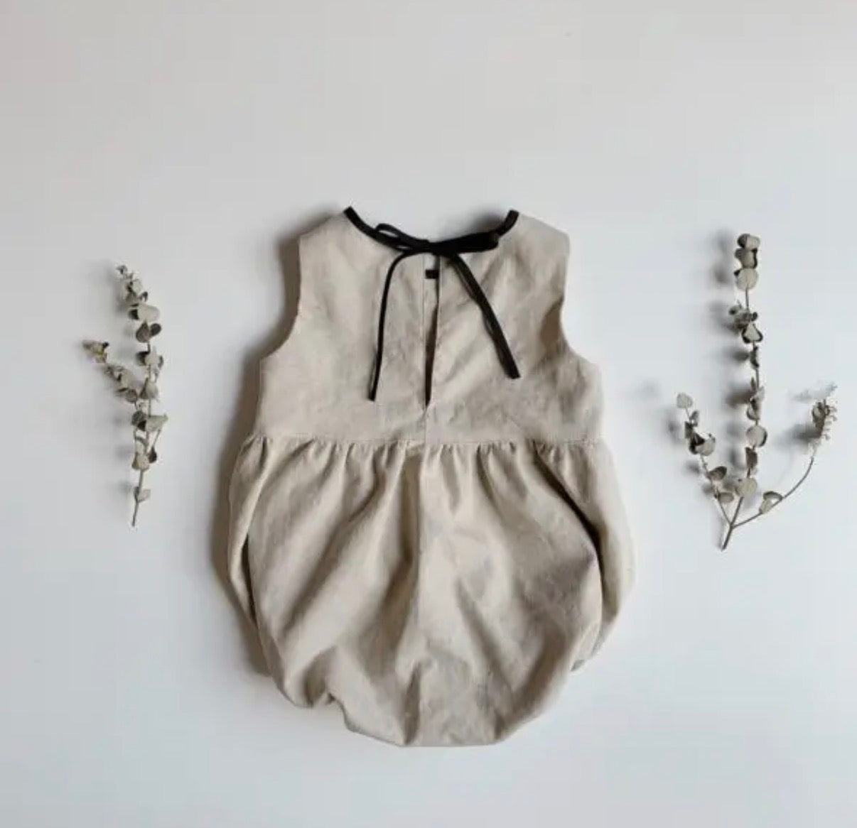 Baby linen romper flat lay product view