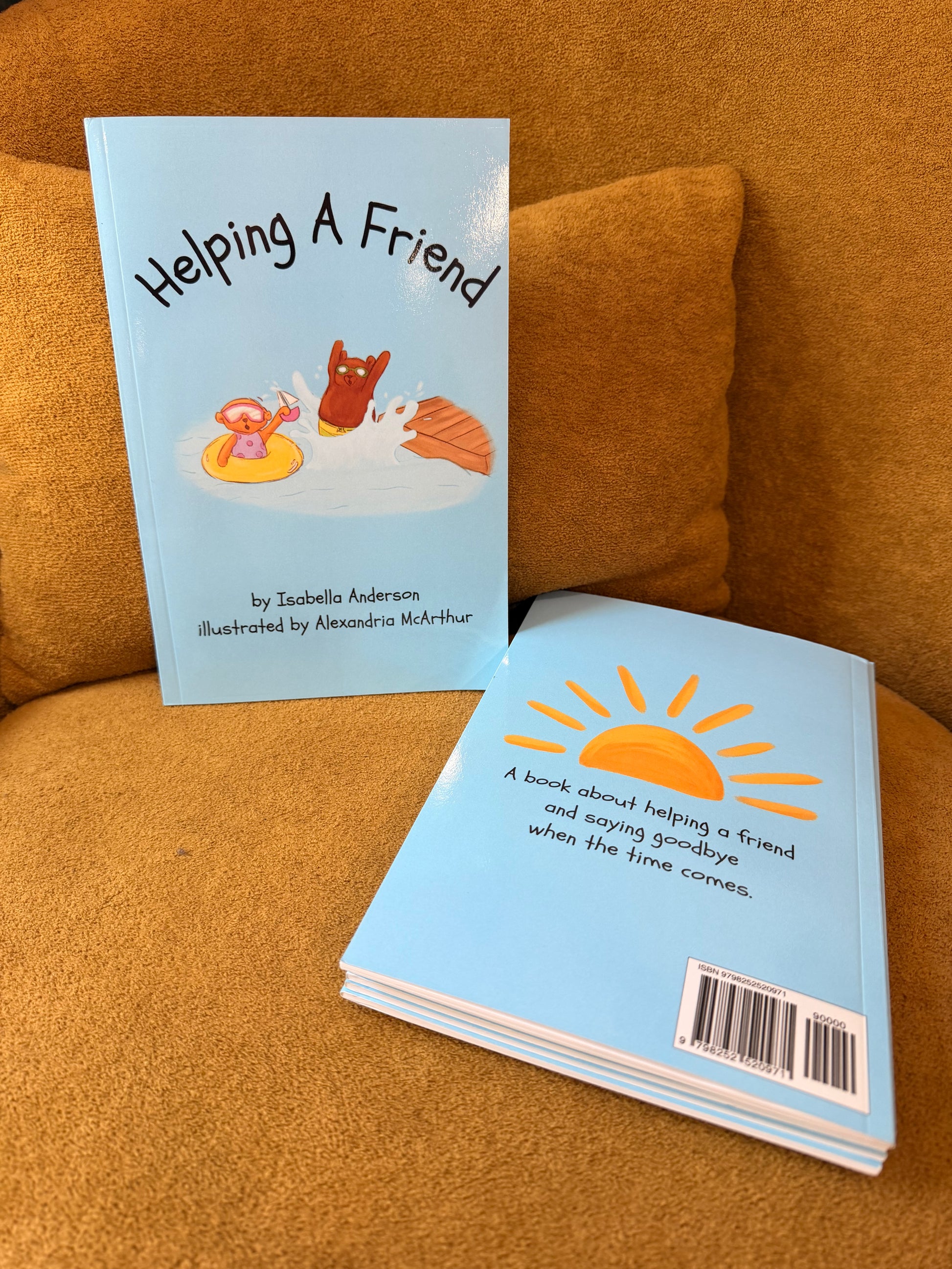 Author Isabella Anderson holding copies of Helping A Friend, a children's foster care picture book