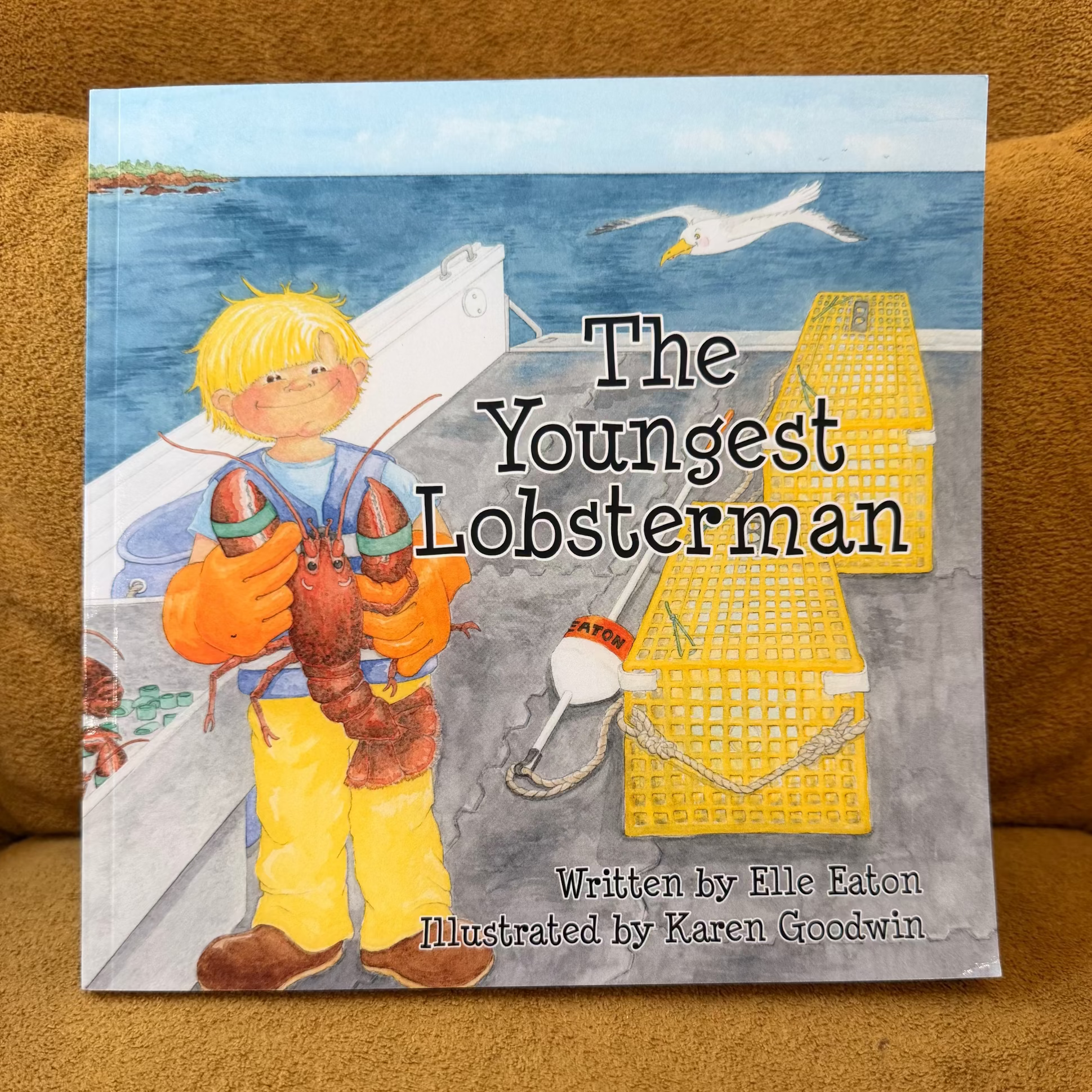 Book titled 'The Youngest Lobsterman' on a brown surface