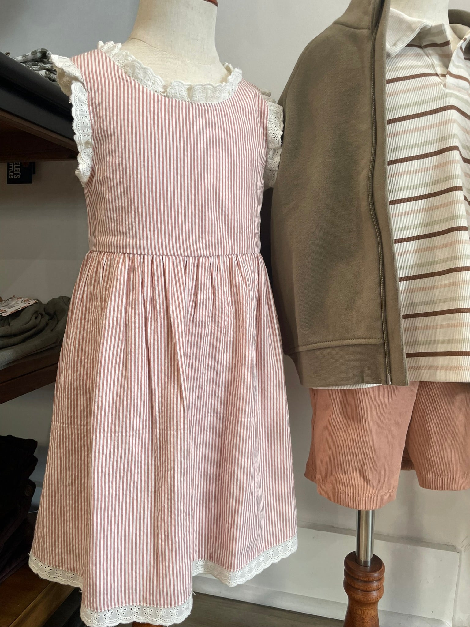 Criss-cross organic cotton baby dress flat lay product view