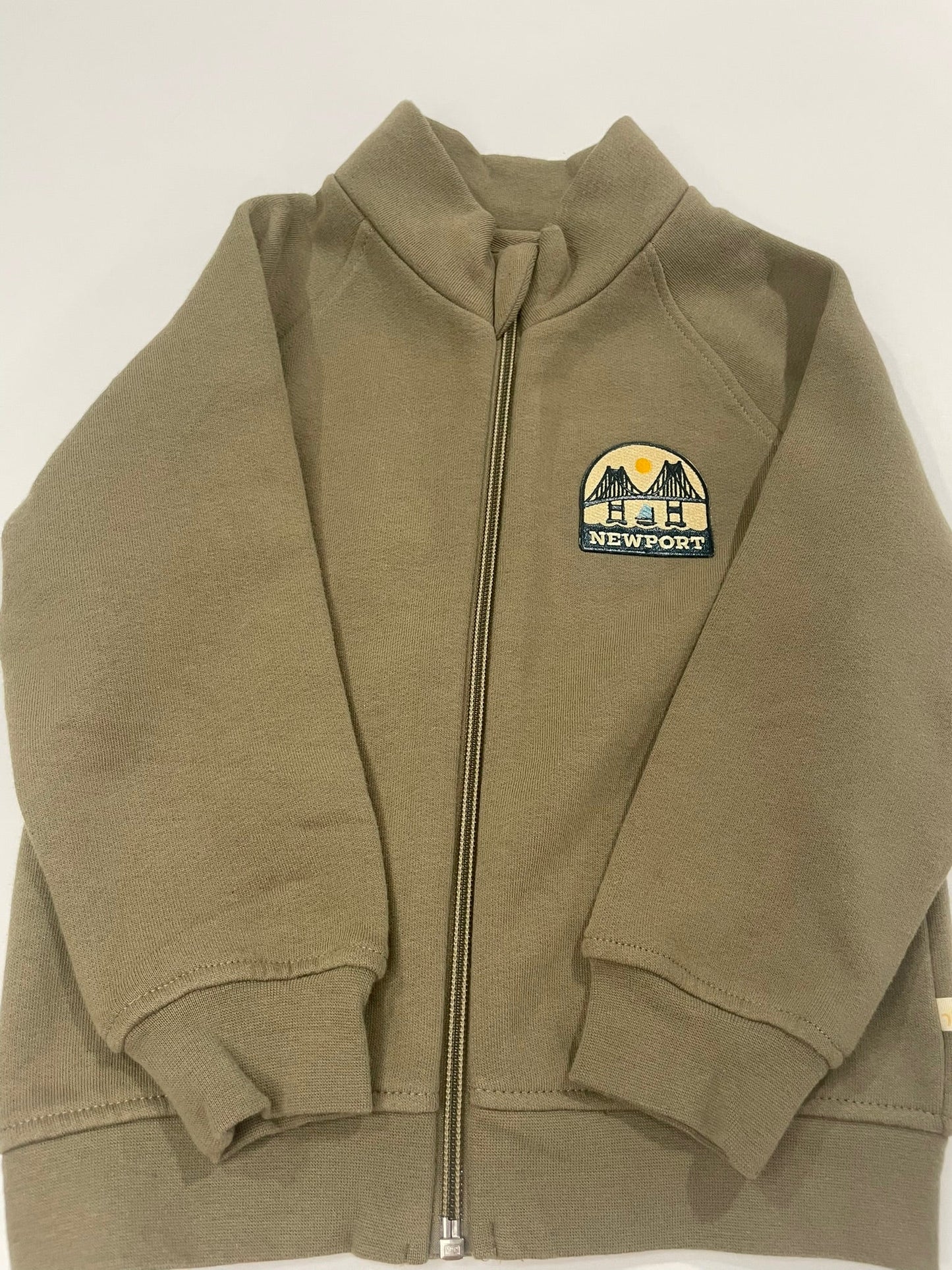 Folded green jacket with a logo on a white background
