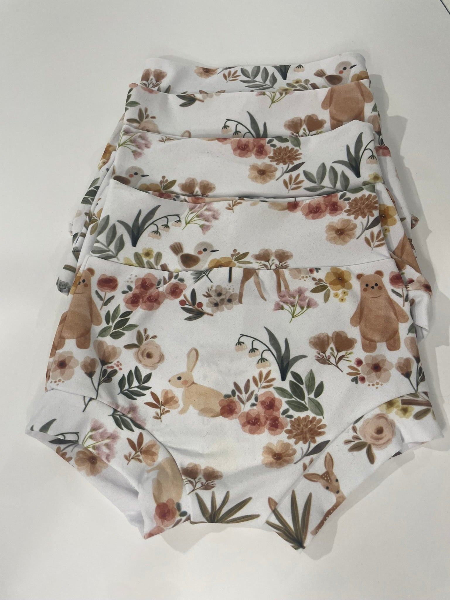 Floral woodland baby bummies flat lay product view