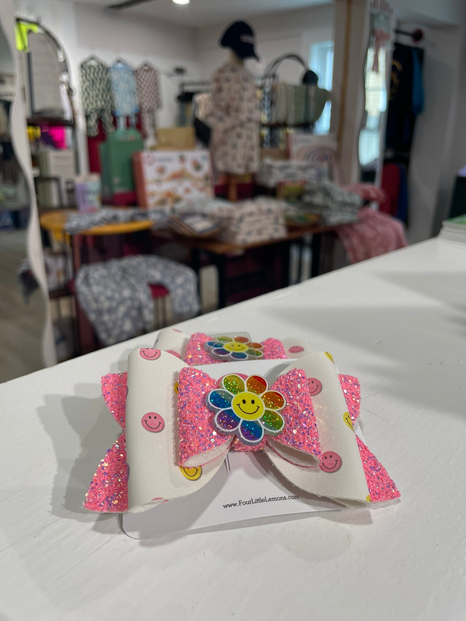 Colorful hair bow with a flower design on a white surface in a store setting.
