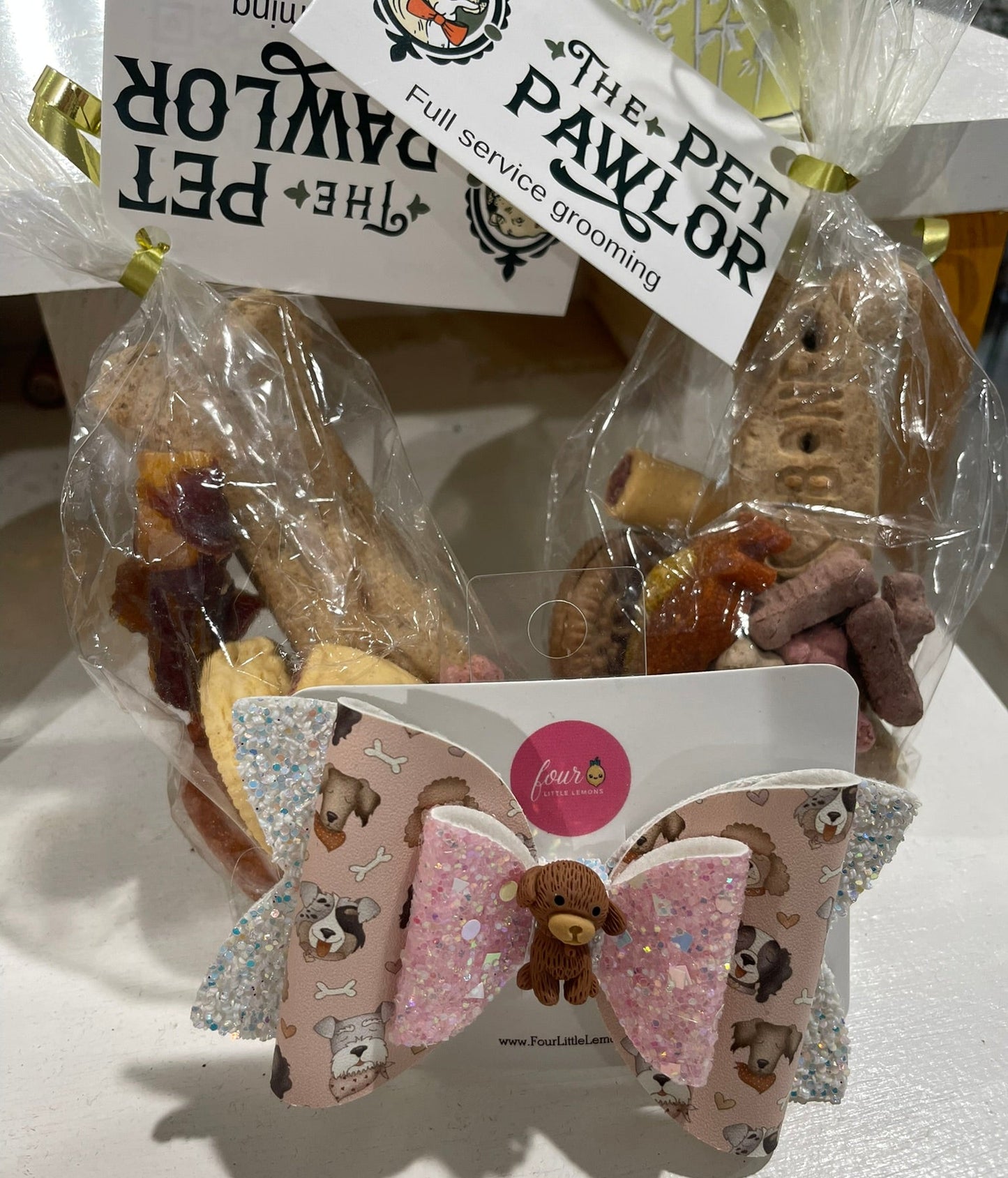 Dog treats in clear packaging with 'The Pet Pawlor' branding, accompanied by a decorative bow.