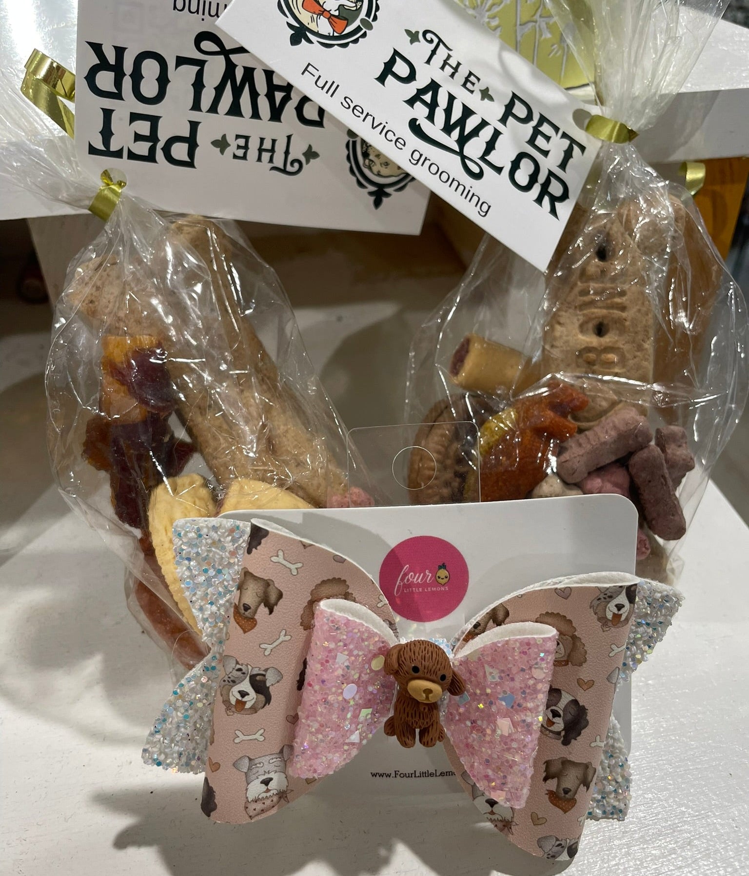 Dog treats in clear packaging with 'The Pet Pawlor' branding, accompanied by a decorative bow.