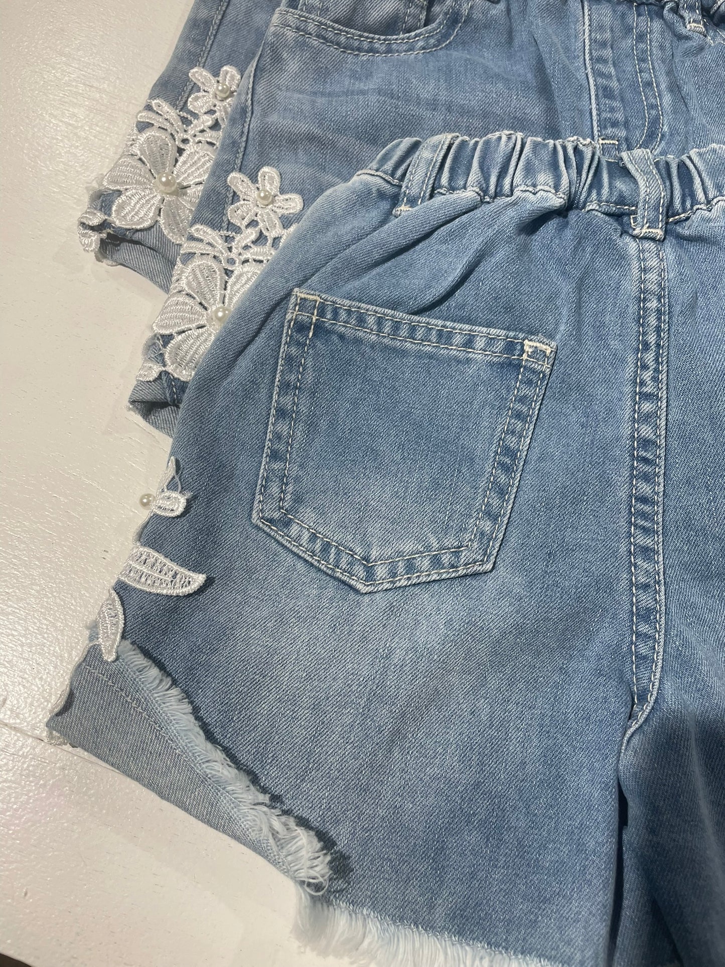 Lace patch denim shorts close up lace and fabric detail