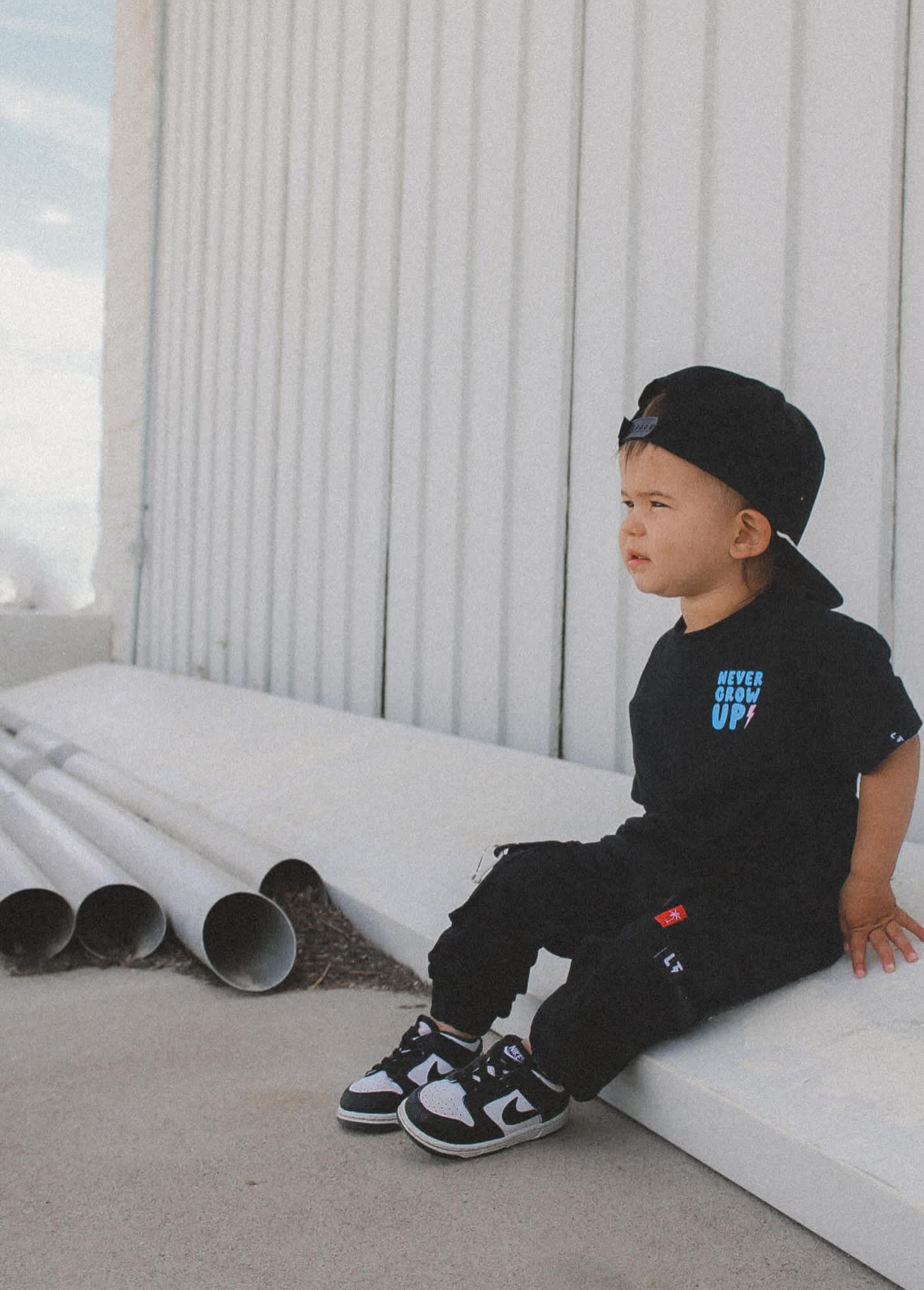 Kids black cargo pants close up of LT keychain tab and pocket detail