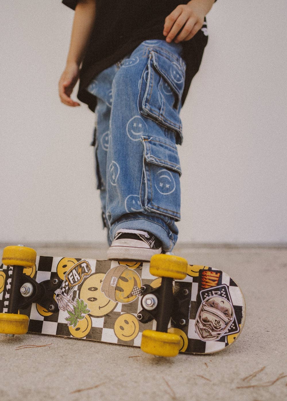 Kids baggy jeans with all-over smiley print close up cargo pocket detail