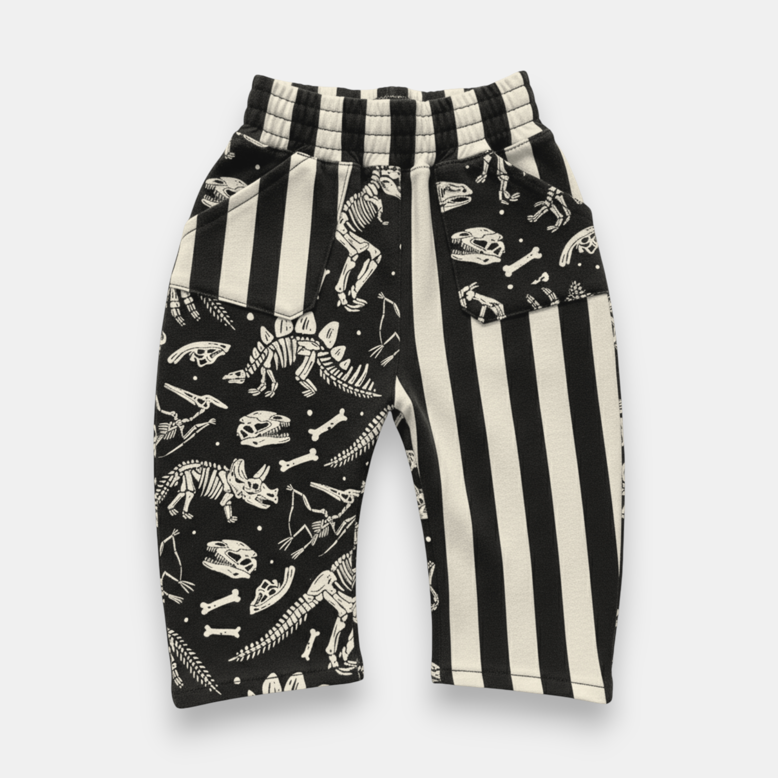 Patchwork dino baggy pants for kids with black and bone stripe fossil print front view
