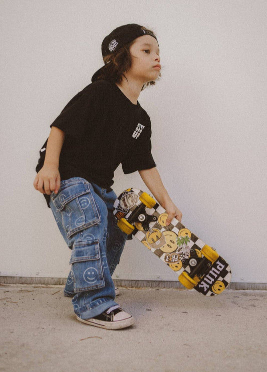 Smiley face baggy jeans for kids with all-over print and cargo pockets front view